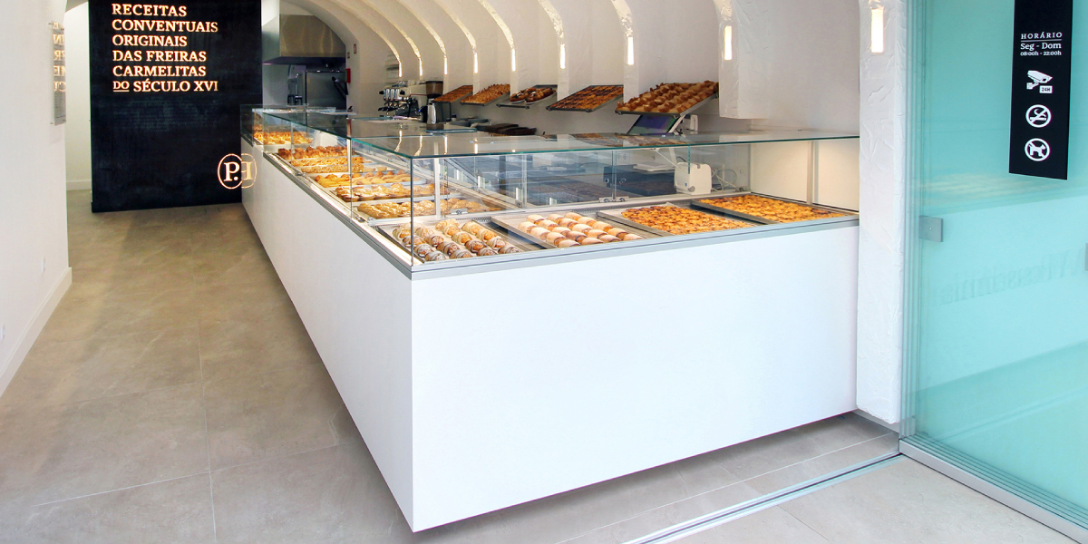 Vitrinas Minimal da JORDAO com vidros altos e decora&ccedil;&atilde;o a branco com interiores em a&ccedil;o inox, com destaque para o modelo canto.